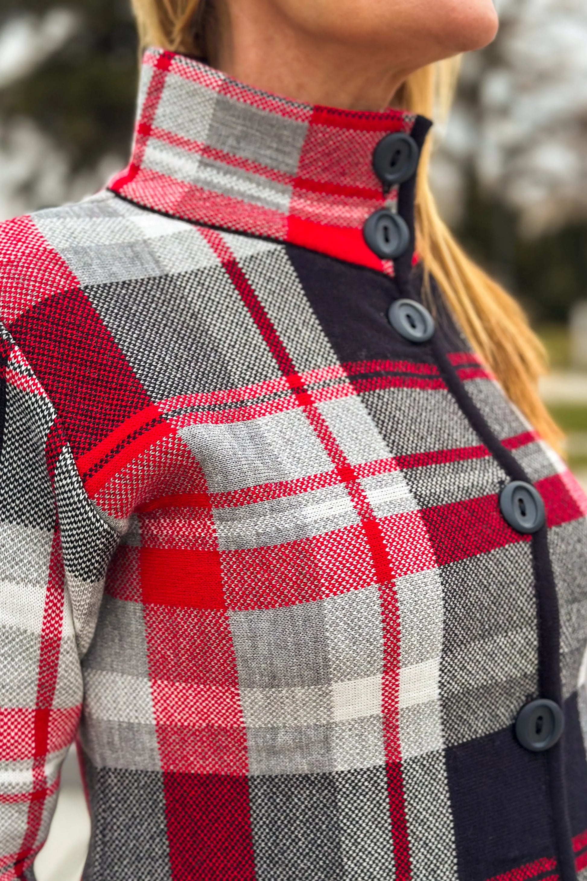 Elegant plaid wool-blend coat in red and black worn by a stylish model.