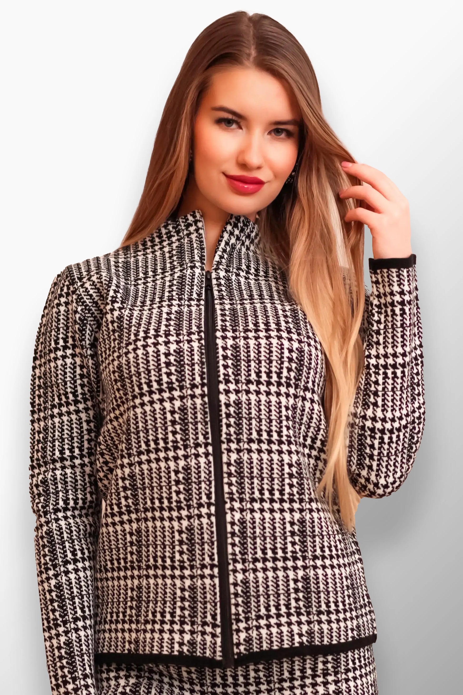 Model wearing a modern black and white plaid short coat with a zippered front.