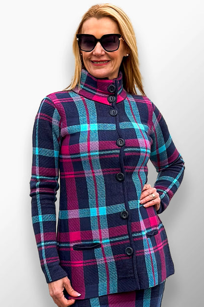 Woman wearing a navy and pink plaid short coat with a high neck buttoned design.